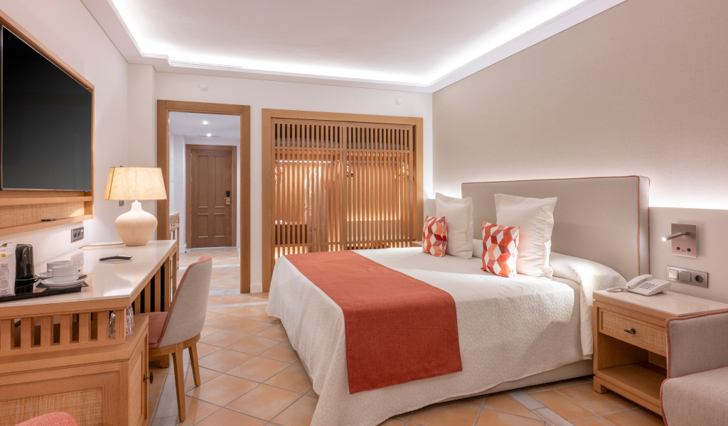 Chambre d'hôtel moderne à Tenerife avec lit double, bureau et télévision.