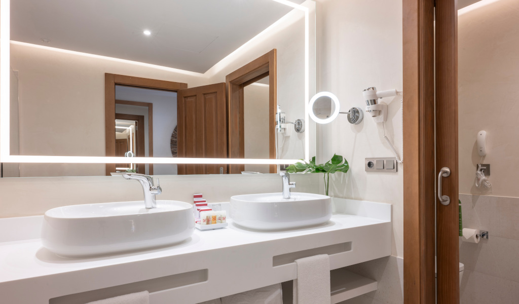 Deux lavabos blancs avec miroirs éclairés dans une salle de bain à Tenerife.