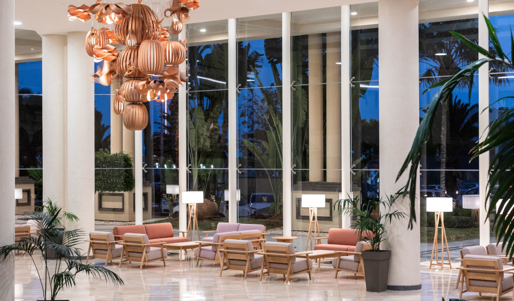 Salon lumineux avec canapés et lampes modernes, vue sur jardins à Tenerife.
