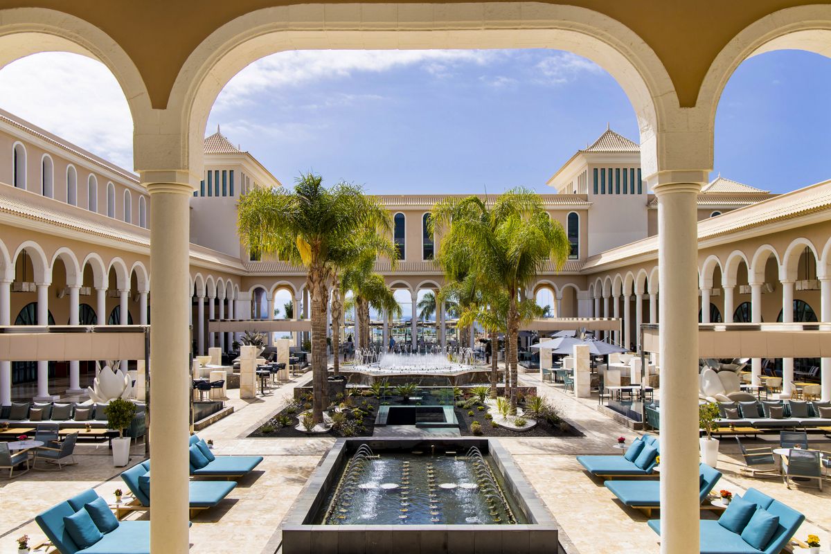 Cour intérieure avec fontaines, palmiers et chaises longues à Tenerife.