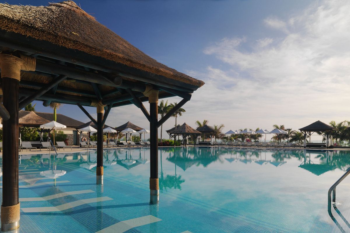 Piscine extérieure avec parasols et palmiers à Tenerife.