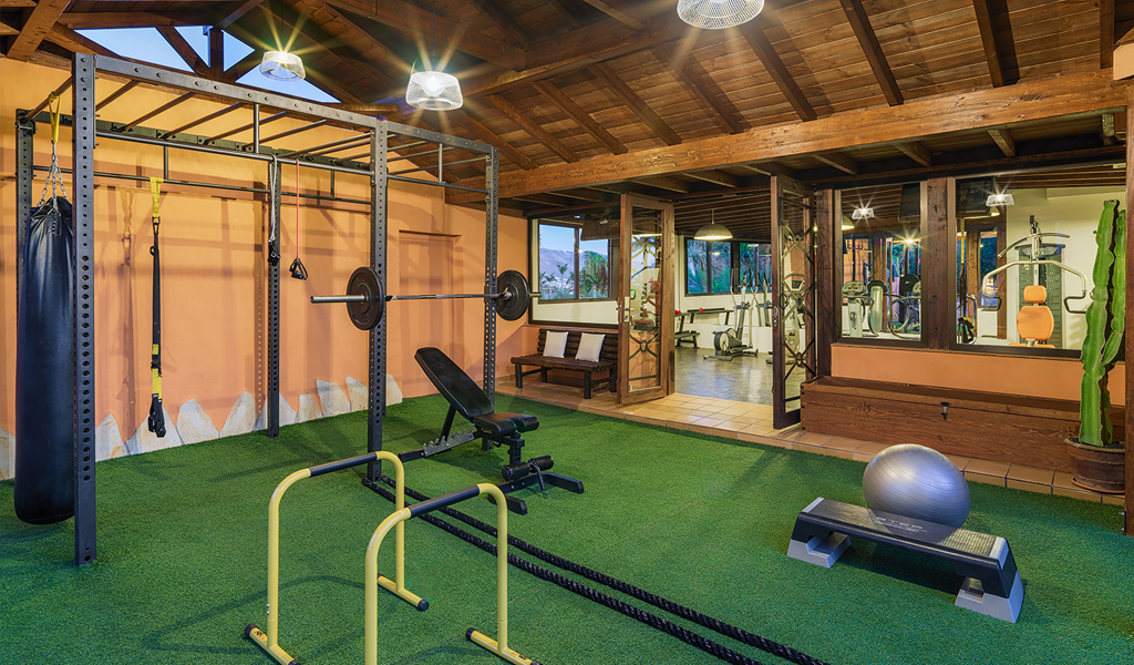 Salle de sport à Tenerife avec équipements de musculation et fitness.