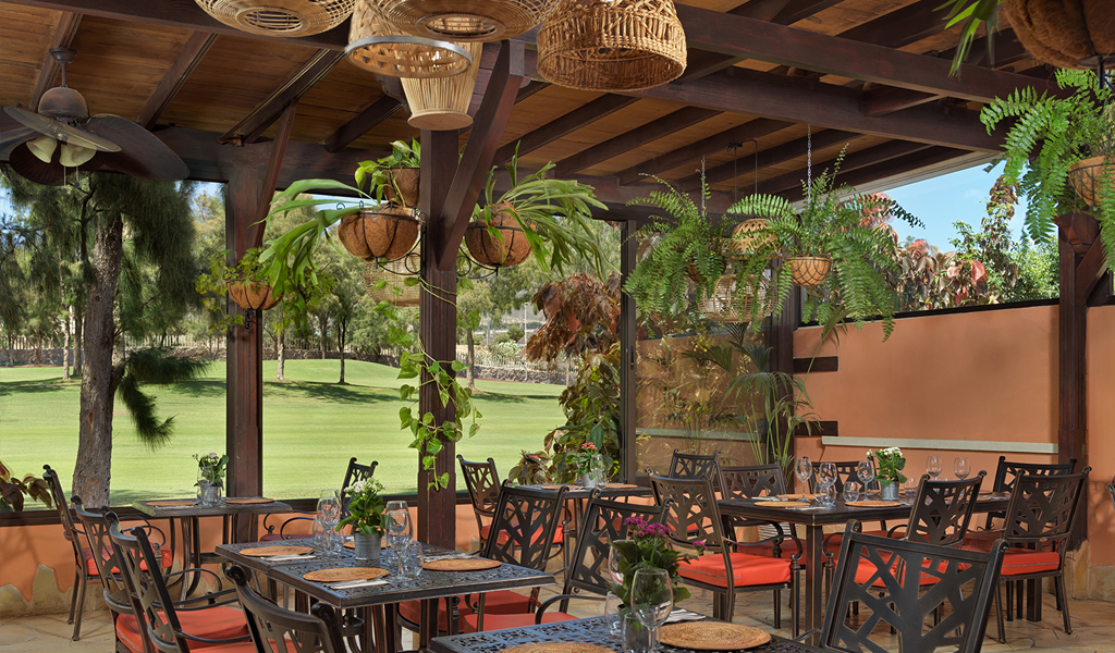 Terrasse extérieure avec tables et chaises près du parcours de golf à Tenerife.
