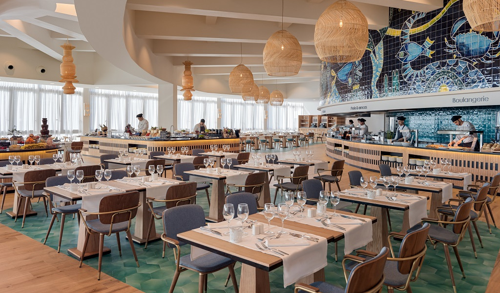 Restaurant élégant à Tenerife avec tables dressées et chefs préparant des plats.