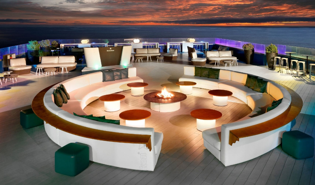 Terrasse avec canapés circulaires autour d'un foyer, vue sur l'océan à Tenerife.