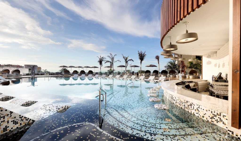 Piscine avec bar et transats à Tenerife sous ciel bleu.