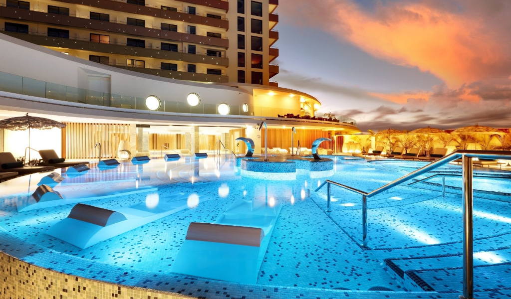 Piscine extérieure éclairée à Costa Adeje, Tenerife, au crépuscule.