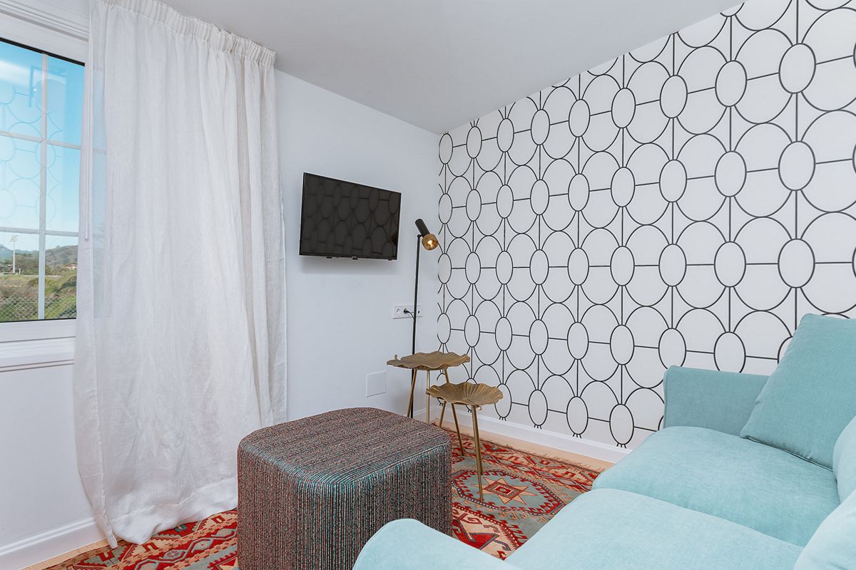 Salon moderne avec canapé bleu, lampadaire et télévision. Vue sur Tenerife.