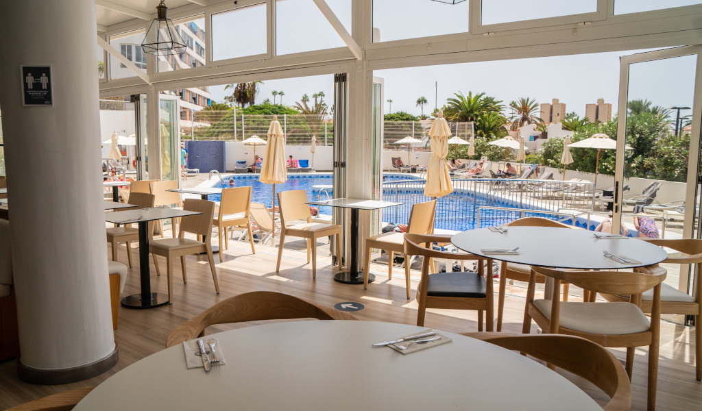 Salle de restauration avec vue sur piscine extérieure à Tenerife.