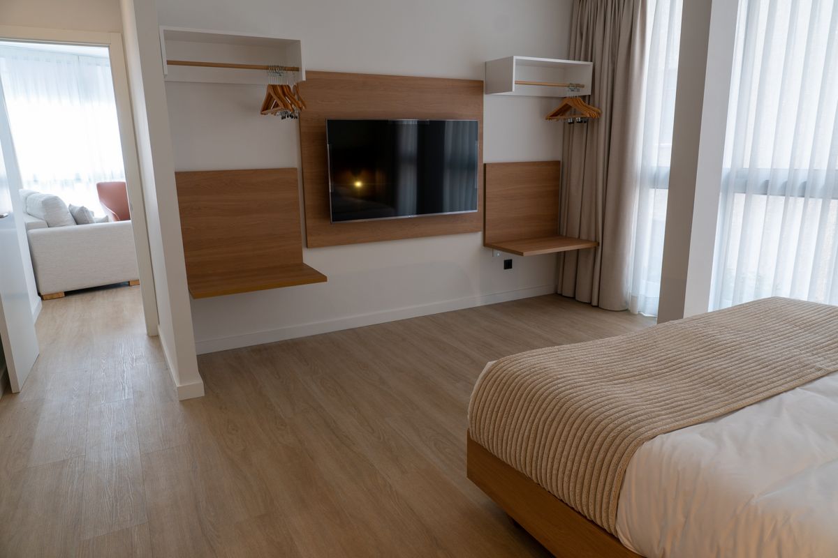 Chambre d'hôtel moderne à Tenerife avec lit, téléviseur et fenêtres.