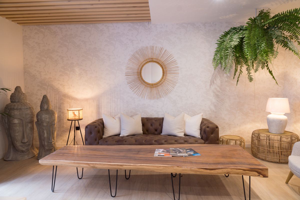 Salon à Tenerife avec canapé, table en bois, miroirs et statues.