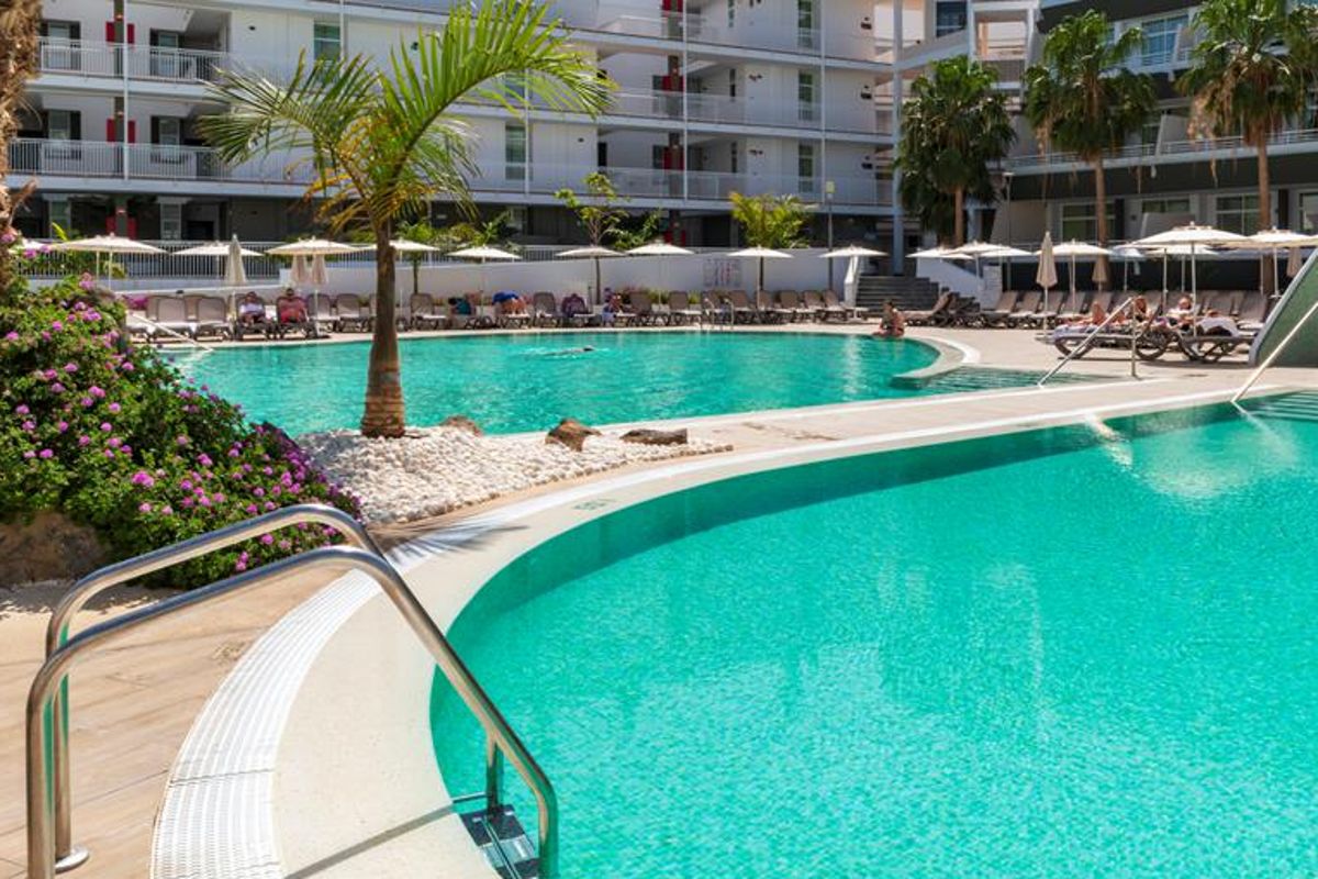 Piscine extérieure avec palmiers et chaises longues à Tenerife.