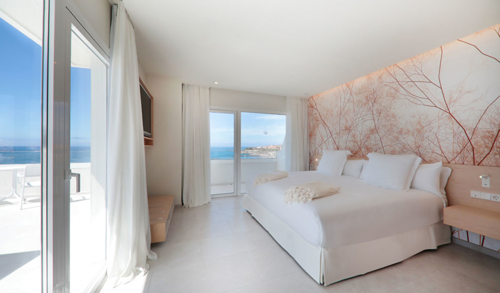 Chambre avec vue sur la mer à Tenerife, lit double et décor mural de branches.