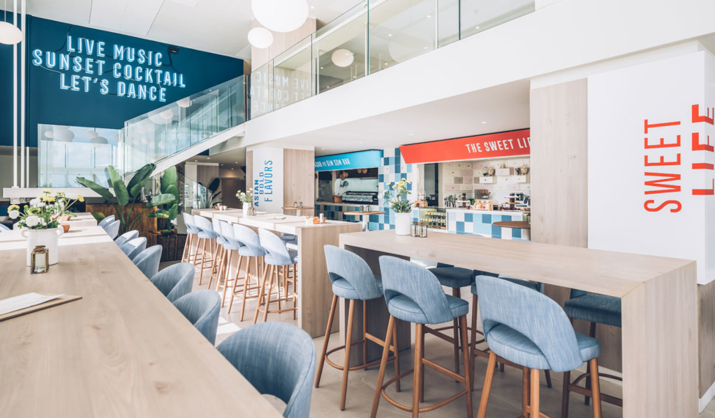 Bar moderne avec chaises bleues et texte, Tenerife : Sweet Life, Live Music.