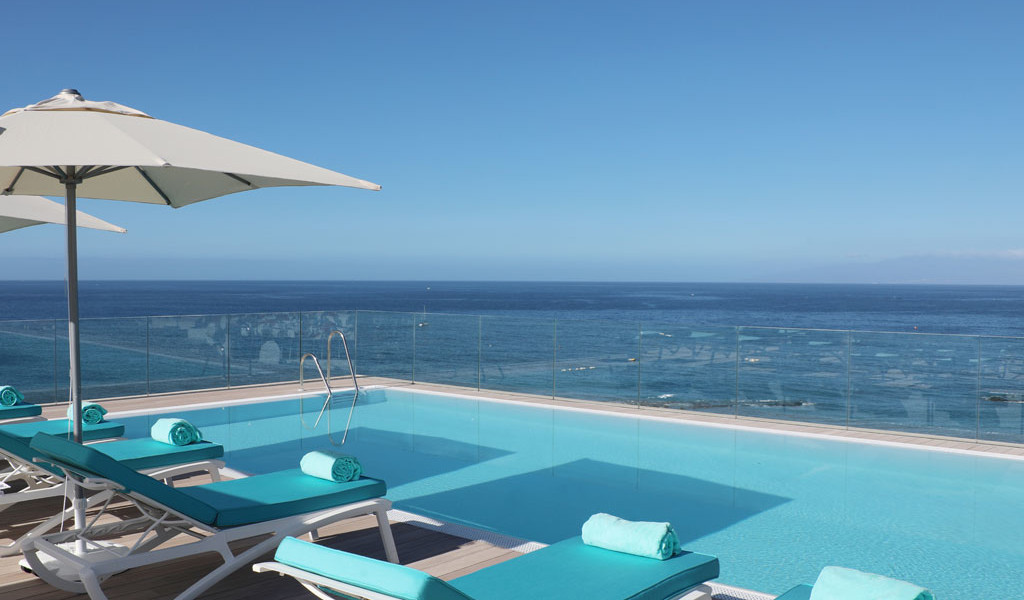 Chaises longues près d'une piscine avec vue sur l'océan à Tenerife.