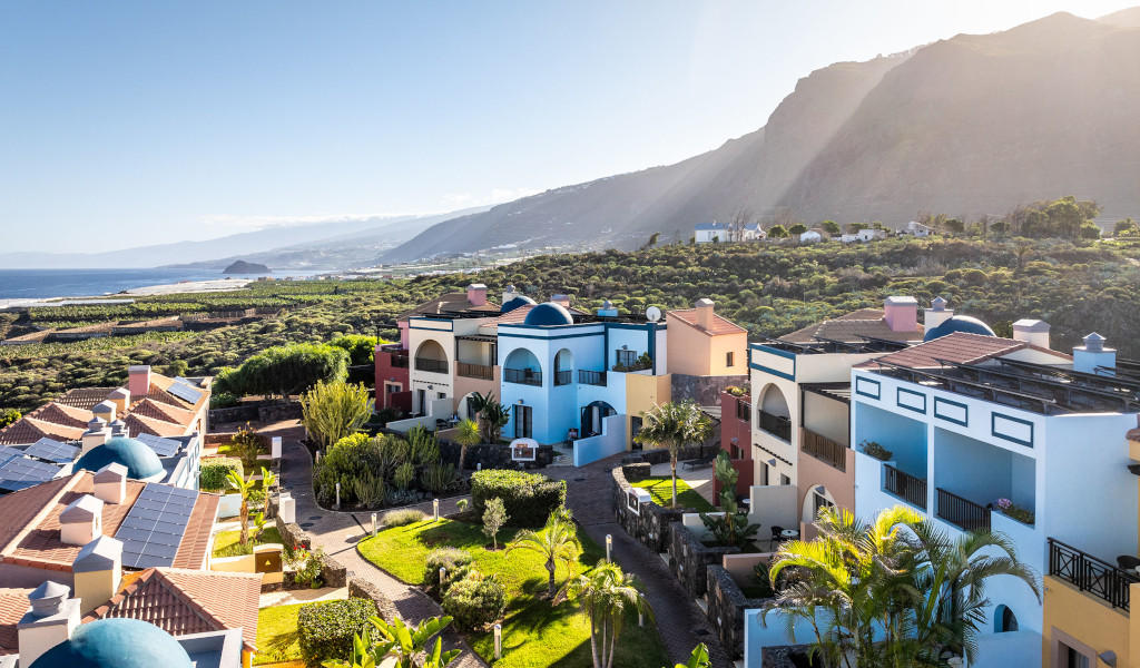 Maisons colorées entourées de verdure avec vue sur mer à Tenerife.