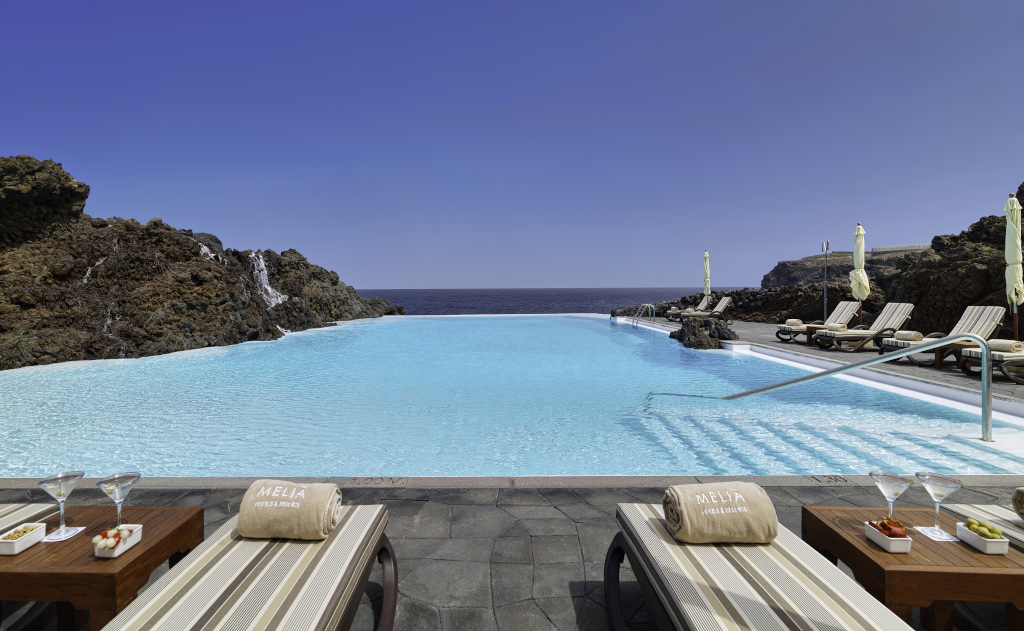 Piscine avec transats face à la mer à Tenerife, serviettes Melia visibles.