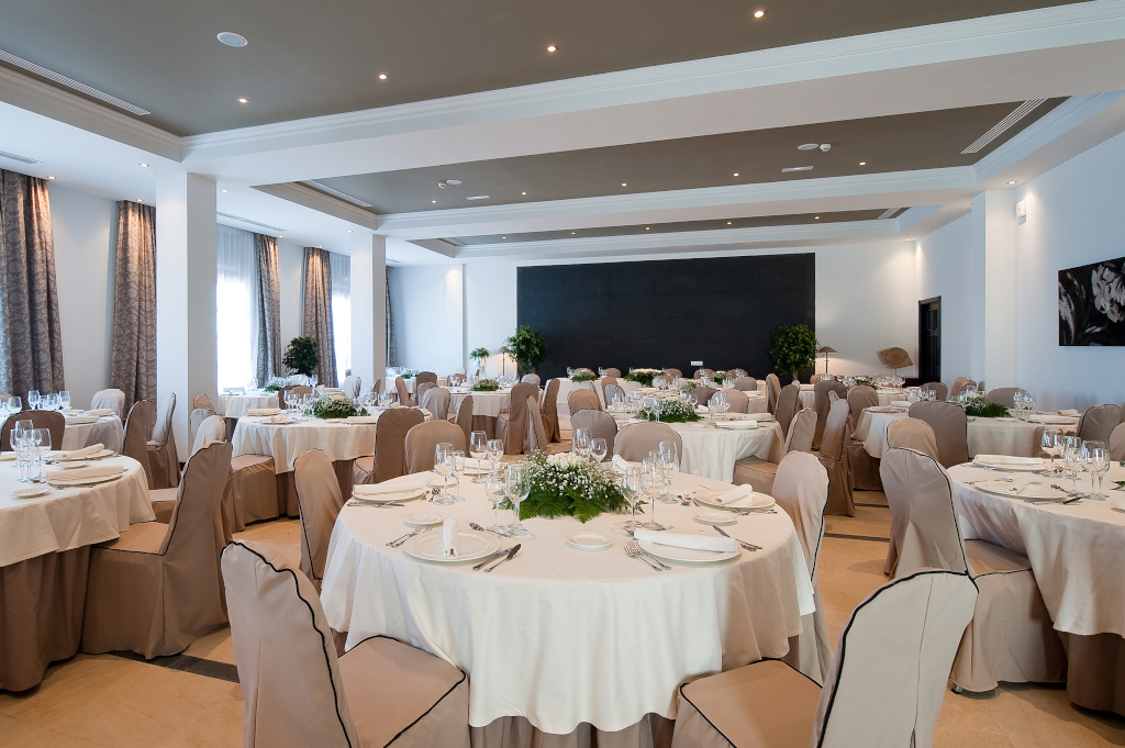 Salle de banquet élégante à Tenerife, tables rondes dressées pour événement.