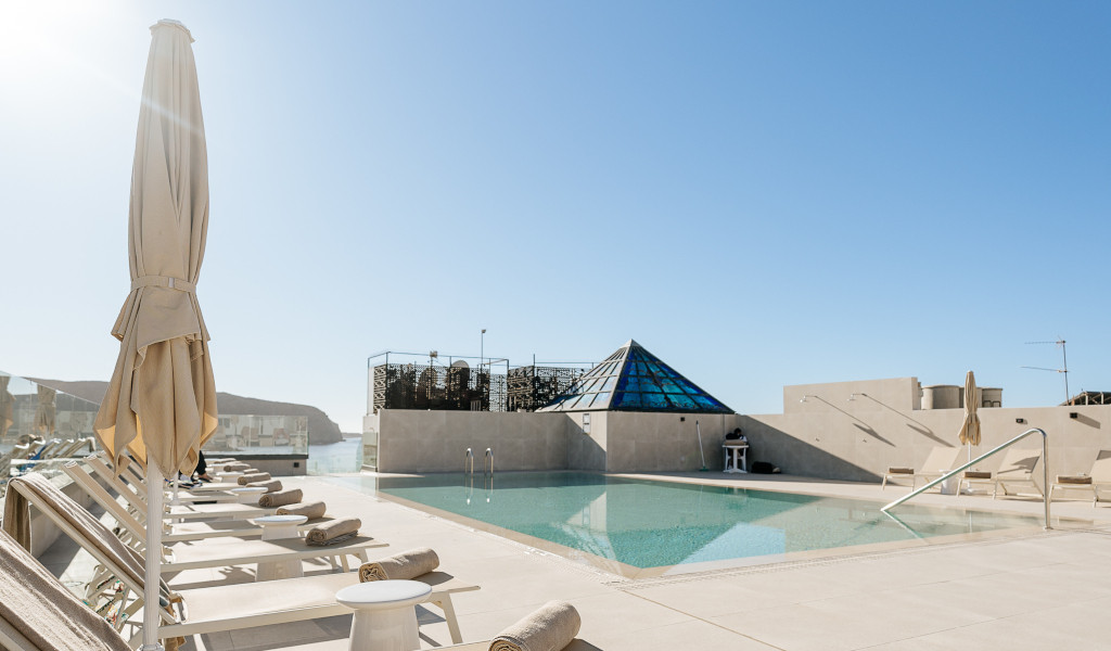 Terrasse avec piscine et chaises longues à Tenerife sous un ciel bleu.