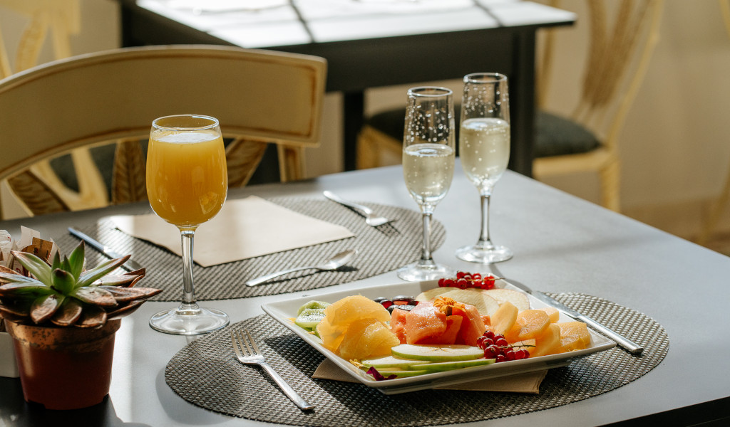 Assiette de fruits avec verre de jus et deux flûtes sur une table à Tenerife.