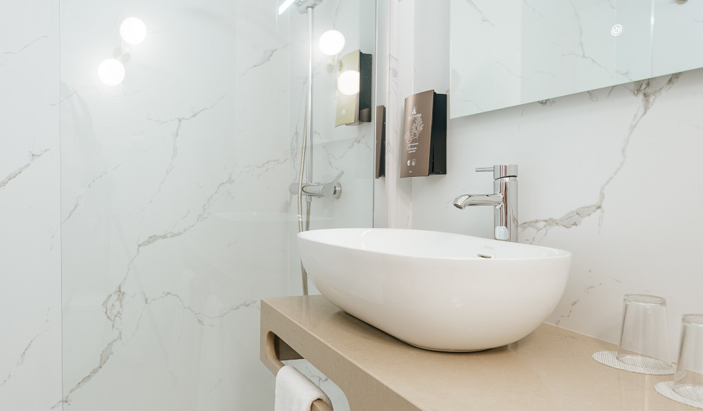 Lavabo moderne avec un miroir et murs en marbre à Tenerife.