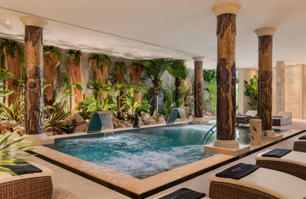 Piscine intérieure entourée de plantes et colonnes sculptées à Tenerife.