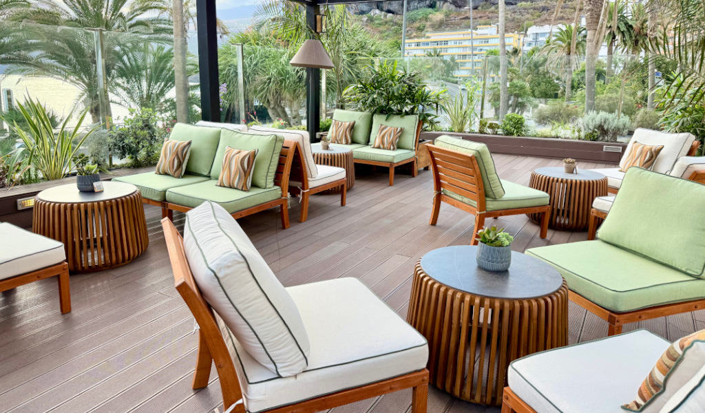 Terrasse avec meubles en bois et coussins verts à Tenerife.