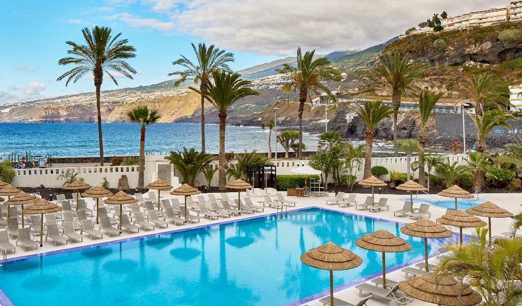 Piscine avec transats et parasols près de l'océan à Puerto de la Cruz, Tenerife.