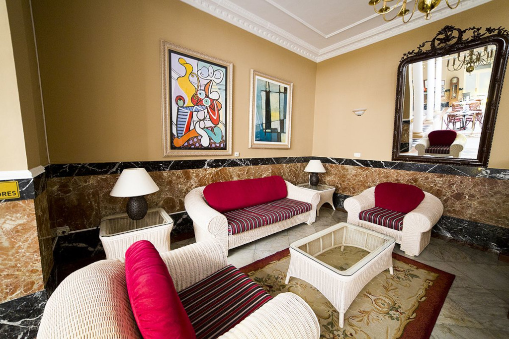 Salon avec canapés rouges et peintures modernes à Tenerife.