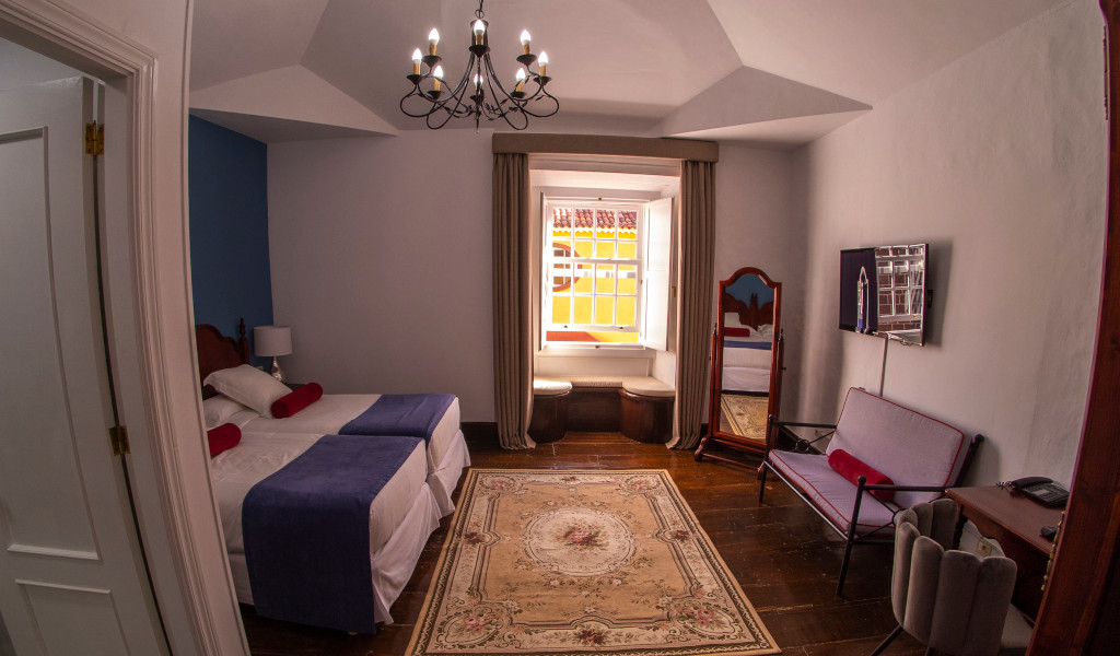 Chambre d'hôtel confortable à Tenerife avec lit double, bureau et fenêtre lumineuse.