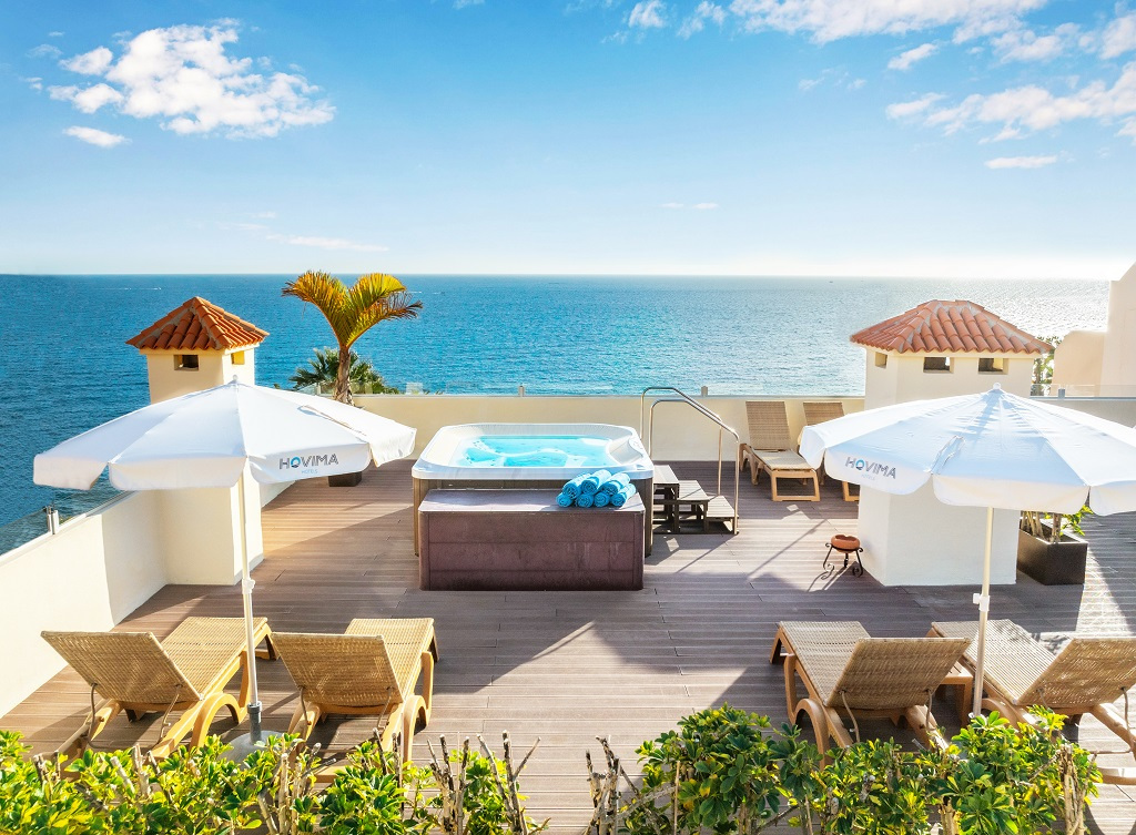 Terrasse avec jacuzzi, chaises longues et parasols à Hovima au bord de la mer, Tenerife.