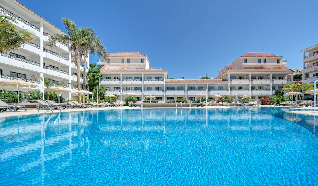 Piscine et hôtels à Tenerife avec palmiers et parasols.