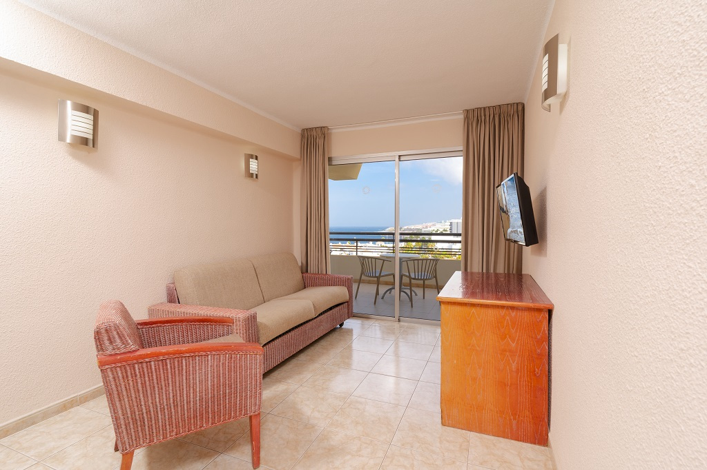 Salon avec canapé, fauteuil et TV, vue sur mer à Tenerife.