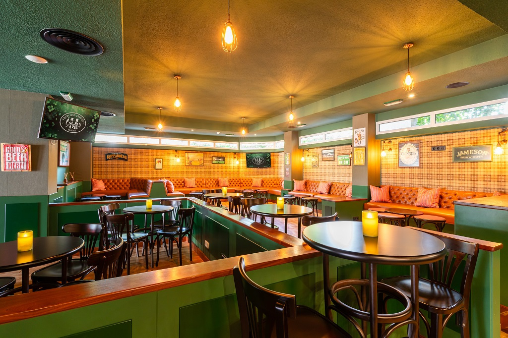 Bar à Tenerife avec tables, chaises, canapés et affiches sur les murs.