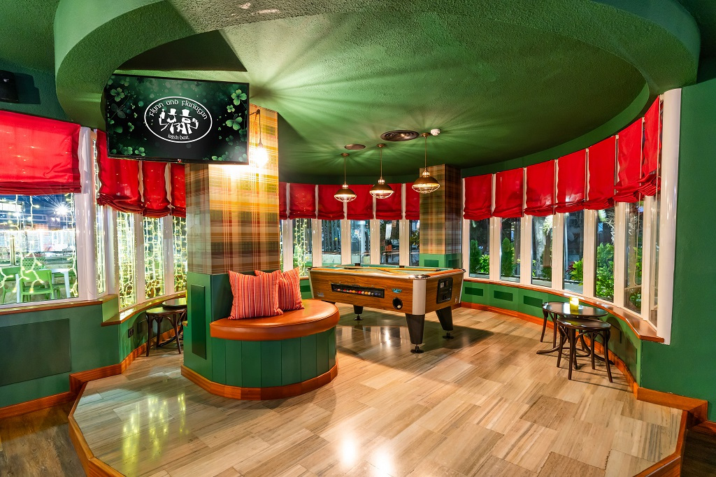Salle de jeux avec baby-foot et coin salon, décorée de rideaux rouges, à Tenerife.