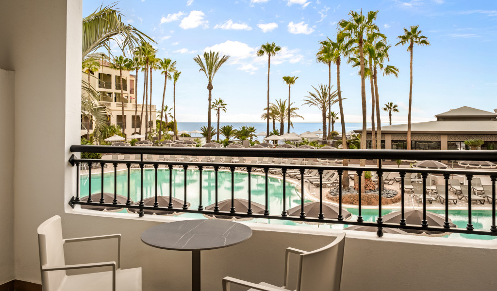Balconnet avec vue sur piscine, palmiers et mer à Tenerife.
