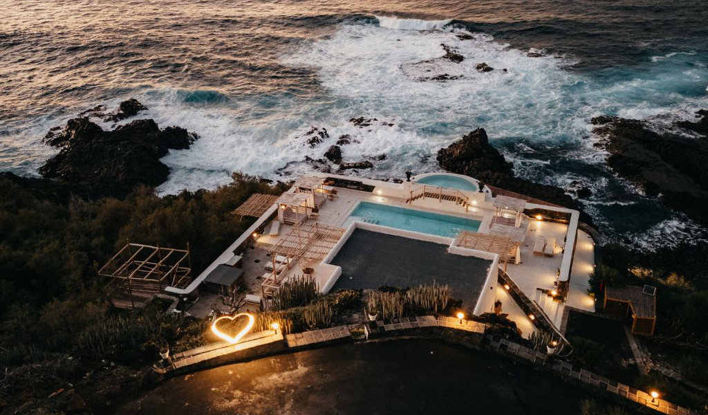 Complexe avec piscine et océan en arrière-plan à Tenerife, illuminé au crépuscule.
