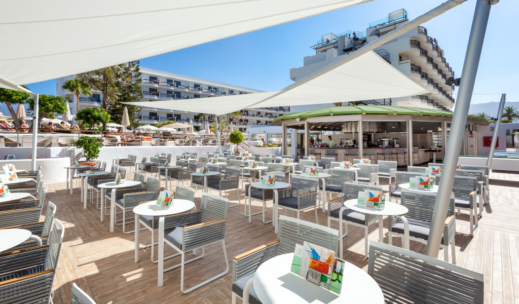 Terrasse avec tables et chaises, vue sur l'hôtel à Arona, Tenerife.