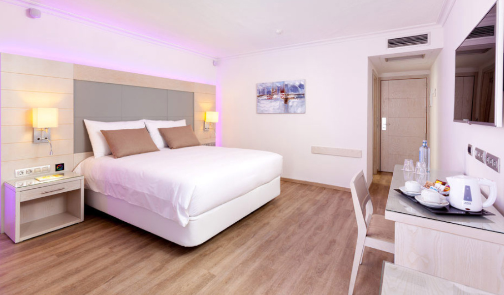 Chambre d'hôtel moderne à Tenerife avec lit double et bureau.