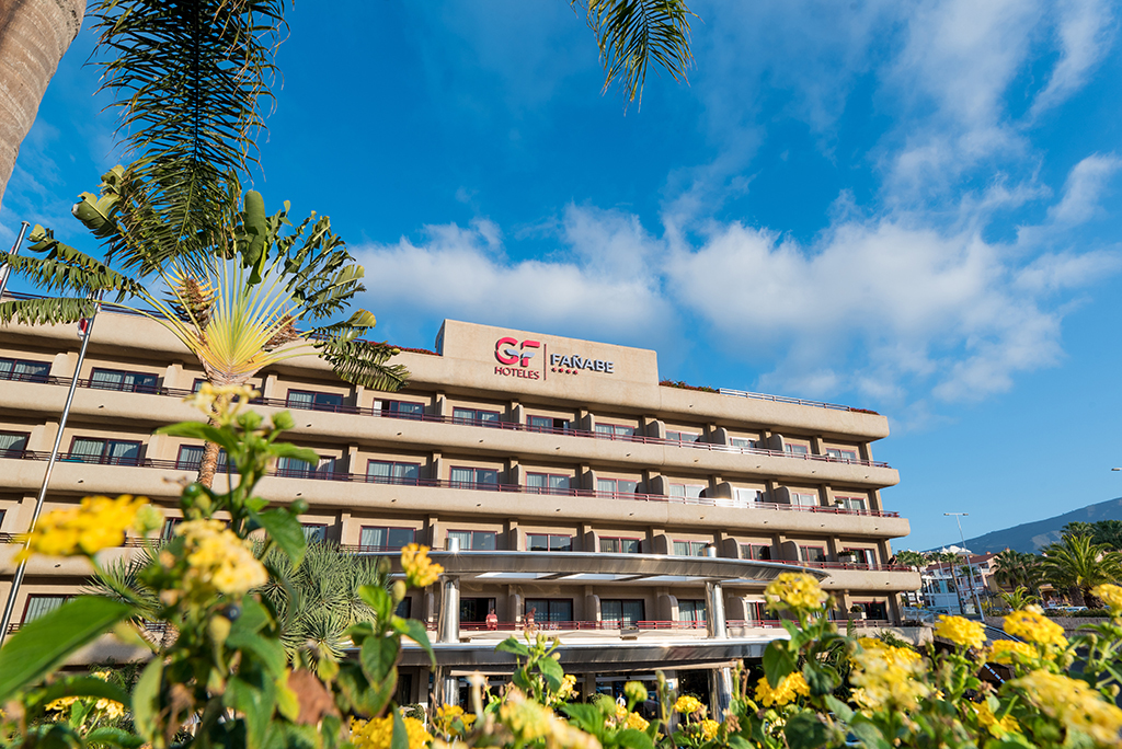 Bâtiment GF Hoteles Fañabe avec palmiers et fleurs à Costa Adeje, Tenerife.