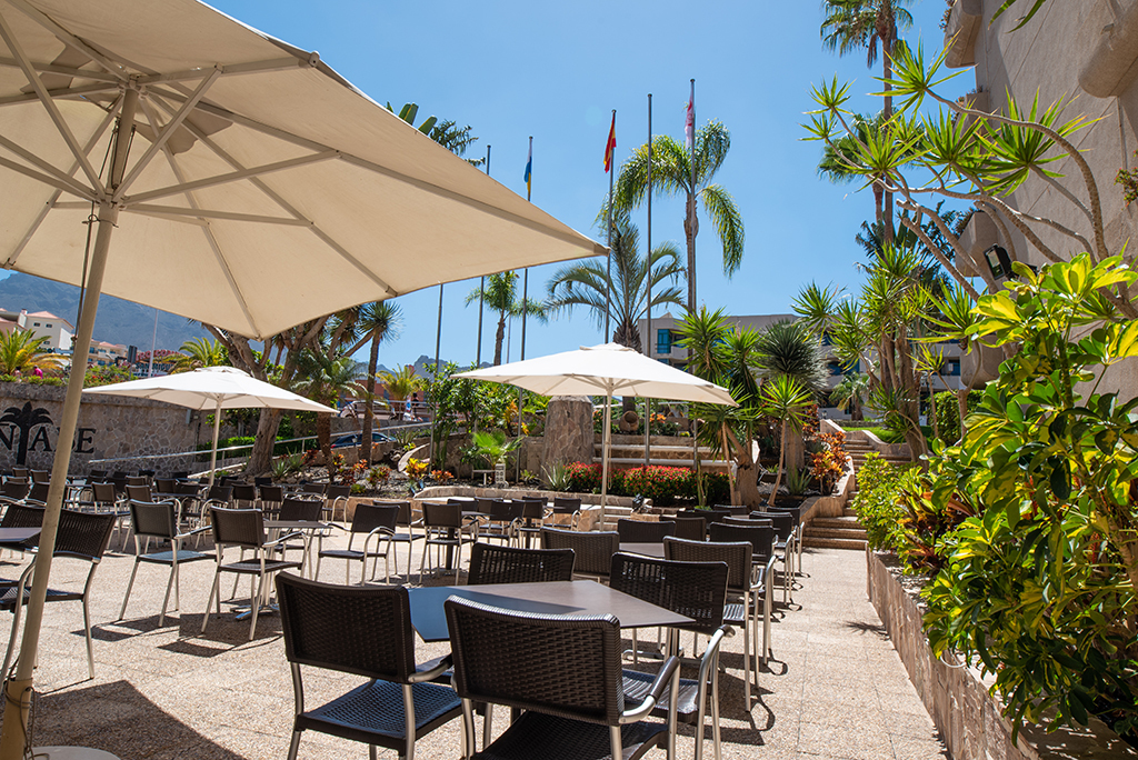 Terrasse ensoleillée avec parasols et palmiers à Tenerife.
