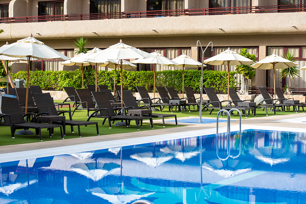 Transats et parasols autour d'une piscine dans un hôtel à Tenerife.