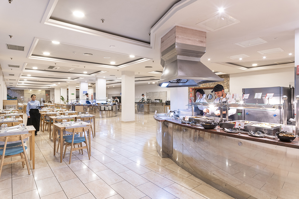Salle de restaurant buffet à Tenerife avec serveur et cuisines.
