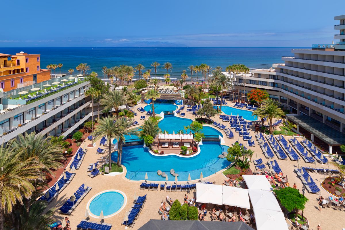 Complexe hôtelier avec piscines et jardins à Tenerife, vue sur la mer.