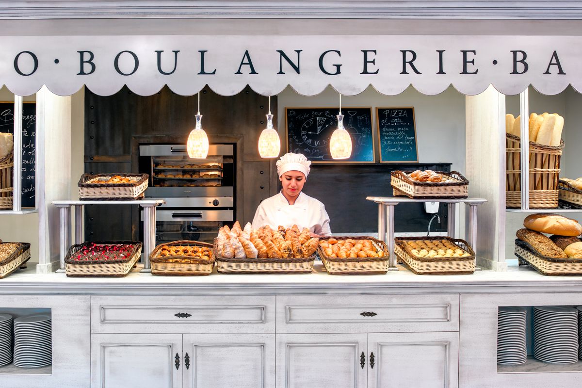 Boulangère à Tenerife avec viennoiseries et pains variés exposés sous enseigne BOULANGERIE.