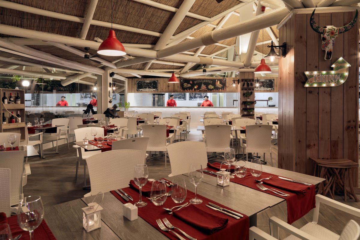 Restaurant à Tenerife avec tables dressées et chefs en cuisine ouverte.