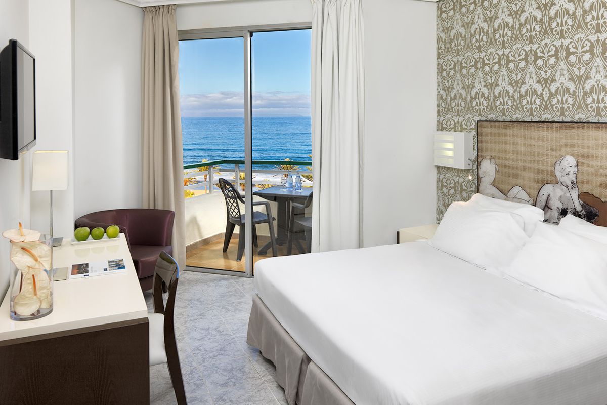 Chambre d'hôtel avec vue sur l'océan à Tenerife, canapé et bureau.