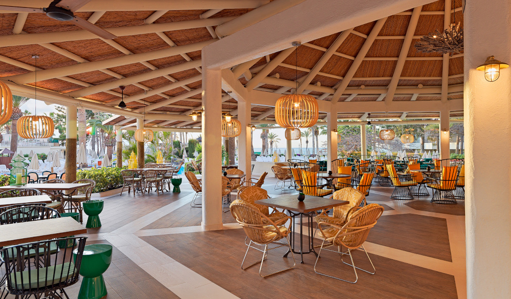 Terrasse extérieure d'un restaurant à Tenerife avec chaises en rotin.