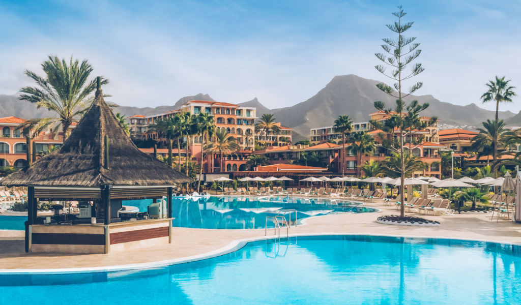 Complexe hôtelier avec piscine entourée de palmiers à Tenerife.