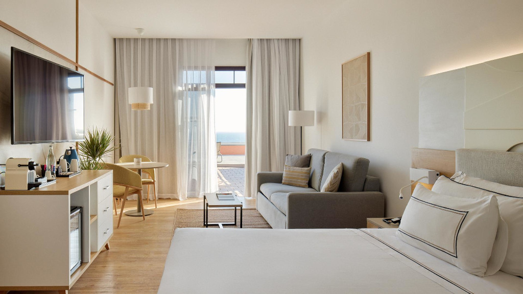 Chambre d'hôtel avec vue sur l'océan à Tenerife, canapé et lit double.